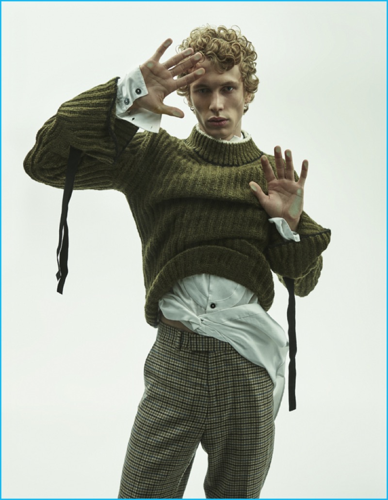 Robbi wears alpaca and wool sweater with elastic ties J.W. Anderson, long cotton gauze shirt Ann Demeulemeester, and wool gingham trousers Gucci.