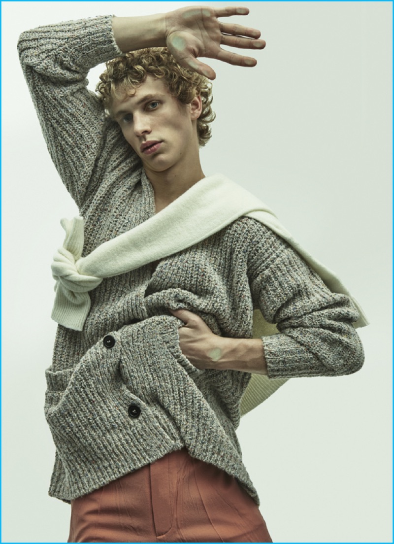 Robbi wears wool crewneck sweater tied around neck Christophe Lemaire and trousers Gucci.