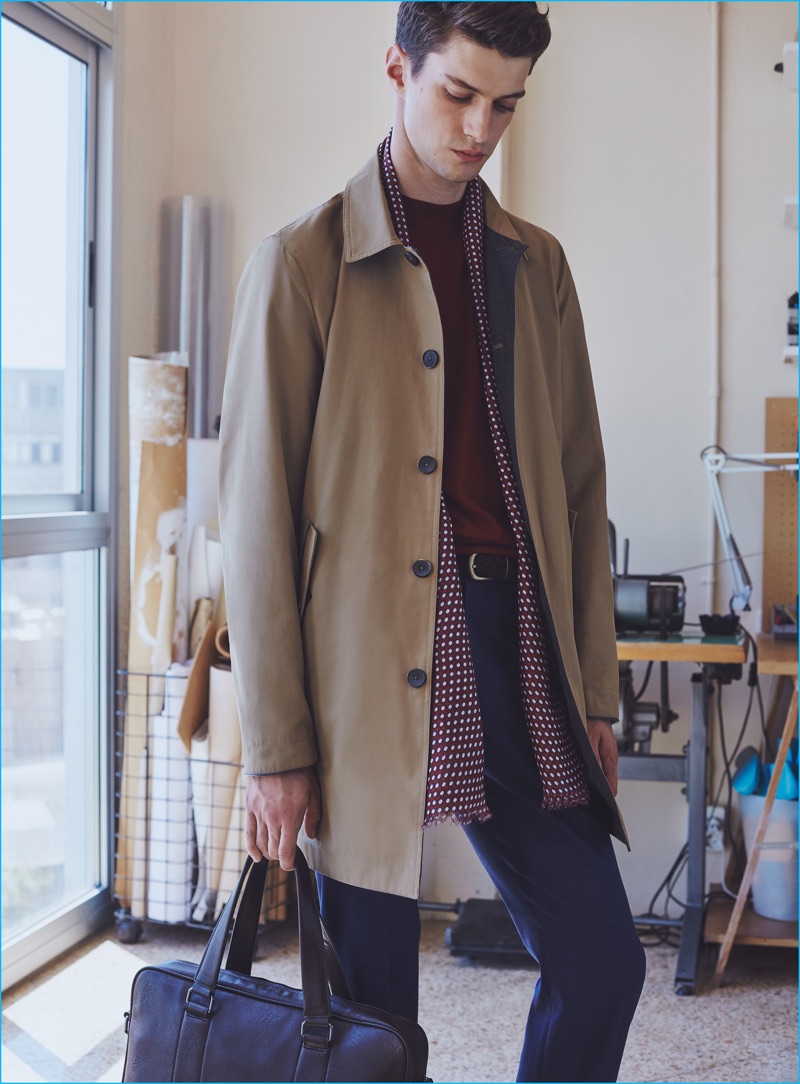 Matthew Bell pictured in a nylon trench coat, accessorized with a patterned scarf from Mango Man.