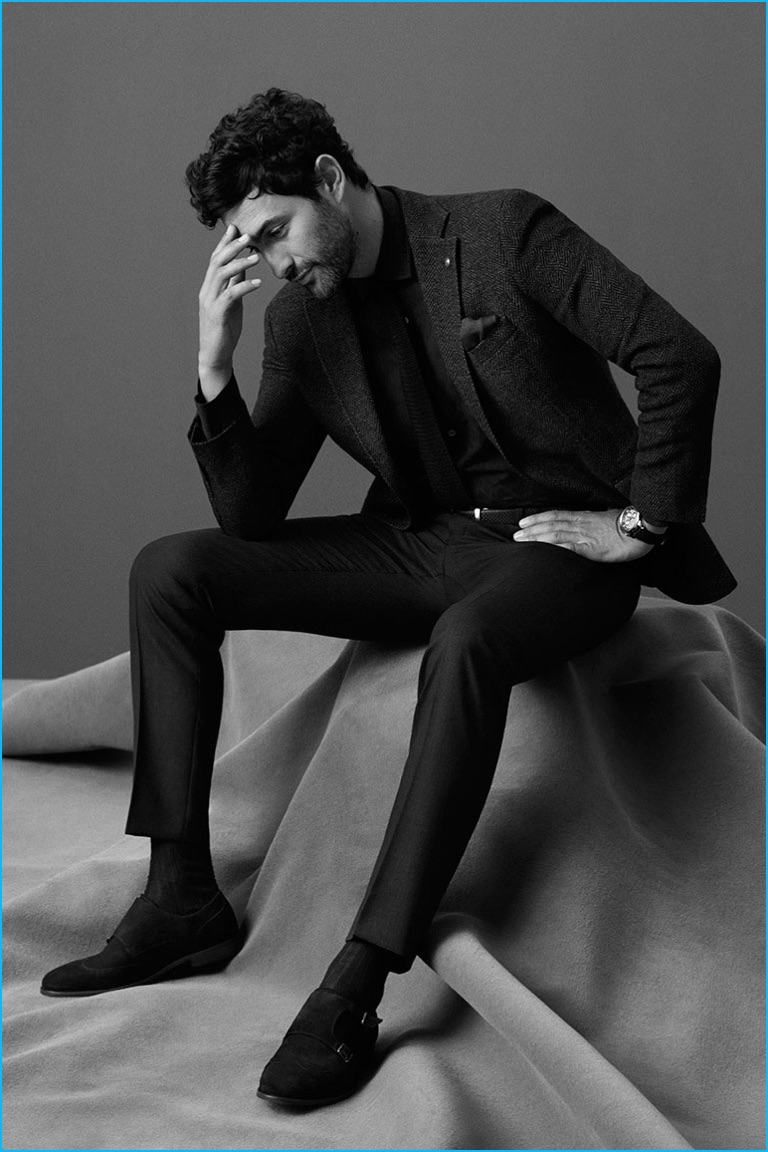 Noah Mills embraces slim lines in pleated trousers and a tweed sport coat from Massimo Dutti.