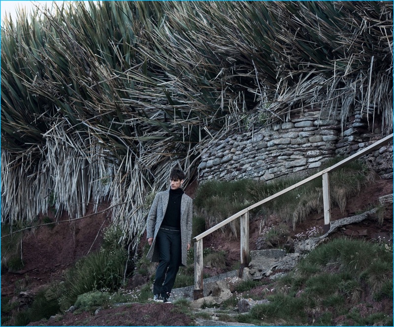 Axel Hermann wears herringbone coat Brunello Cucinelli, turtleneck sweater Lanvin, tuxedo trousers Alexander McQueen, and leather sneakers Pierre Hardy.