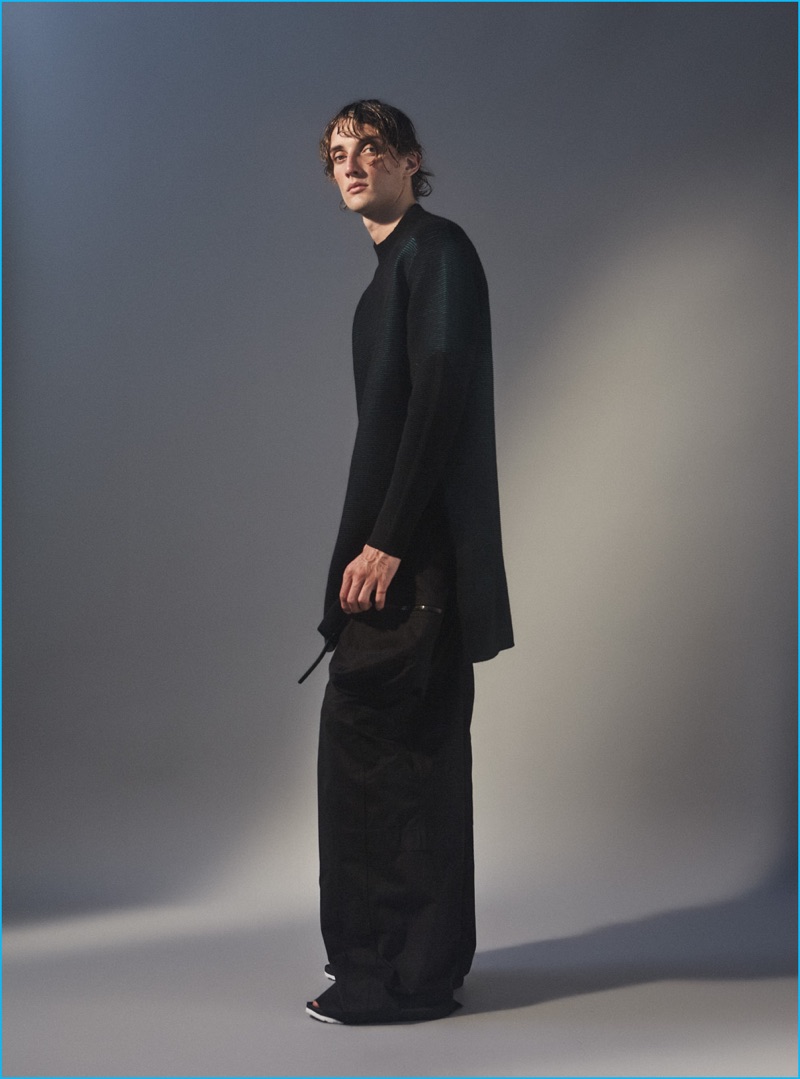 JJ wears elongated ottoman top Y-3, oversized utility trousers Rick Owens, and shoes Nike.
