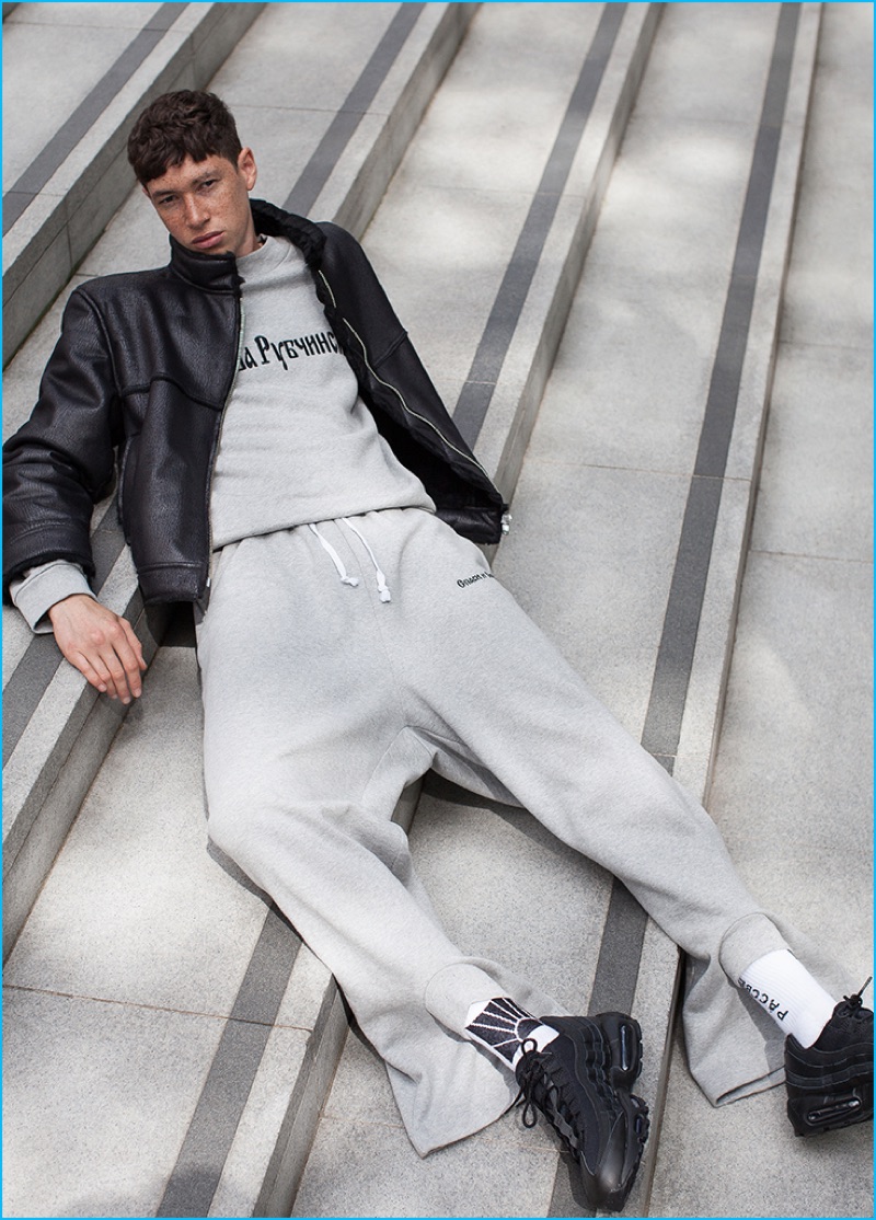 Jos Whiteman wears leather jacket, sweatshirt, and sweatpants Gosha Rubchinskiy, and sneakers Nike.