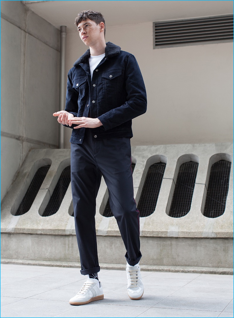 Jos Whiteman wears corduroy jacket Acne Studios, navy pants OAMC, and white sneakers Maison Margiela.