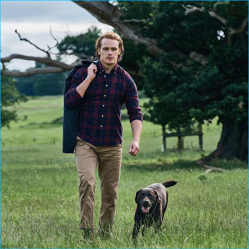 Sam Heughan goes smart casual in a tartan shirt and slim-fit pants from Barbour.