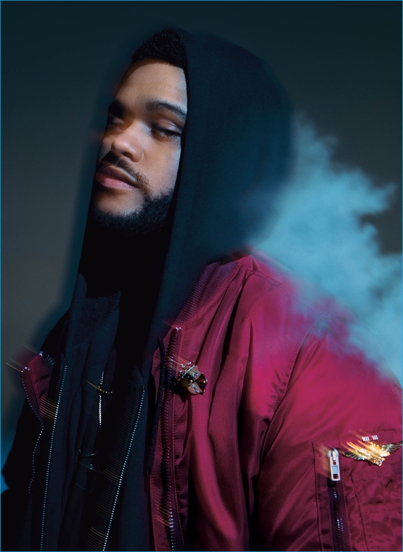 The Weeknd rocks a burgundy Givenchy bomber jacket with a t-shirt and hoodie from Alexander Wang.