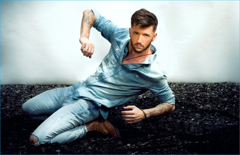Travis Wall doubles down on denim in a shirt and jeans from Rag & Bone with brown leather boots from Moods of Norway.