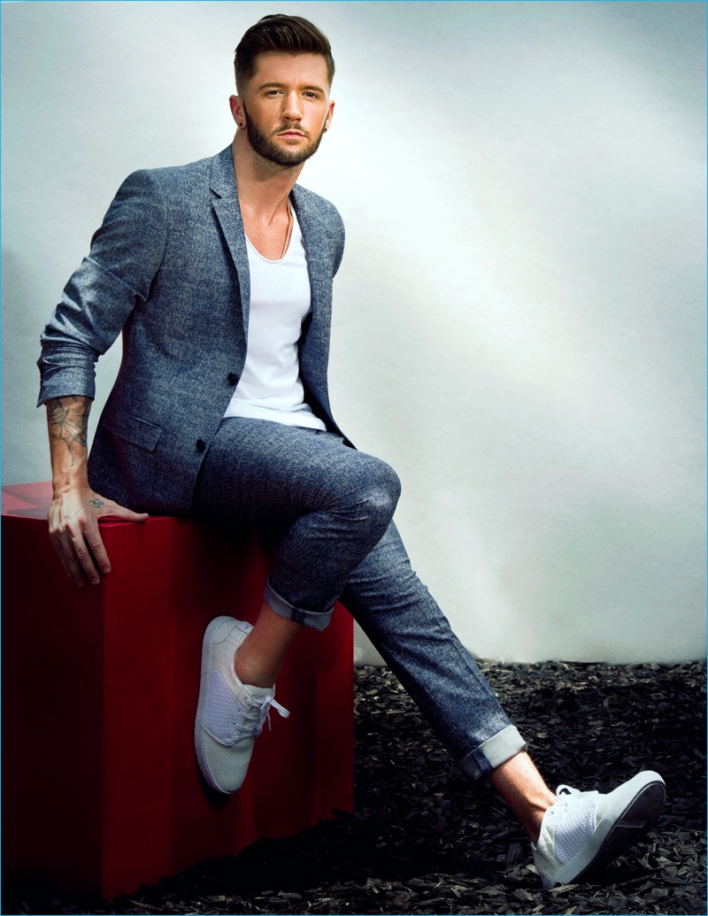 Travis Wall pictured in a Topman suit with a Theory shirt and Creative Recreation shoes.