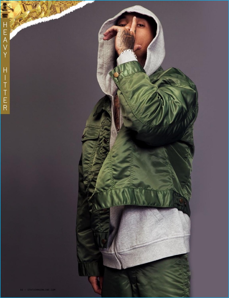 Tyga embraces an army green military-inspired look in a Landlord jacket and pants, layered with an Alexander Wang hoodie.