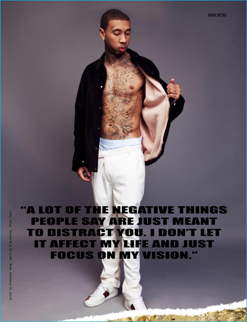 Tyga shows off his tattoos with an open Alexander Wang shirt jacket, R.Swiaderby trousers and white Gucci sneakers.