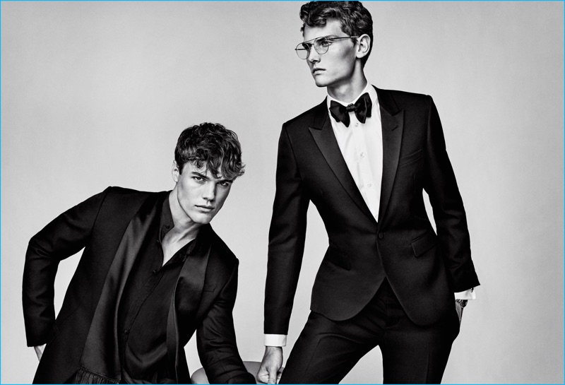 Left to Right: Jacques Pougne wears all clothes Givenchy. Shade Mullins wears shirt Emporio Armani, glasses Mykita, cufflinks Cartier, watch Omega, suit and bow-tie Saint Laurent.