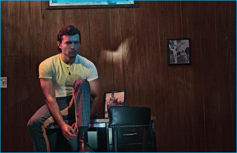 Beat Bolliger outfits Alden Ehrenreich in a vintage Munsingwear t-shirt with check Prada trousers for Interview magazine.