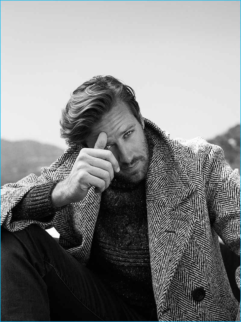 Kurt Iswarienko photographs Armie Hammer in a herringbone Burberry coat, Brunello Cucinelli flecked sweater, and J Brand jeans. 