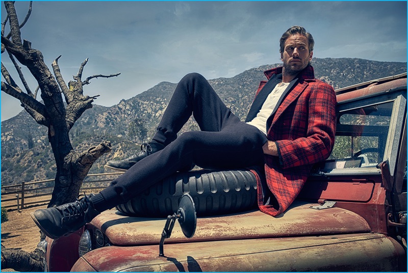 Actor Armie Hammer wears a red and black plaid Gucci coat, an Etro jacket, Joe's henley, and Tom Ford pants. 