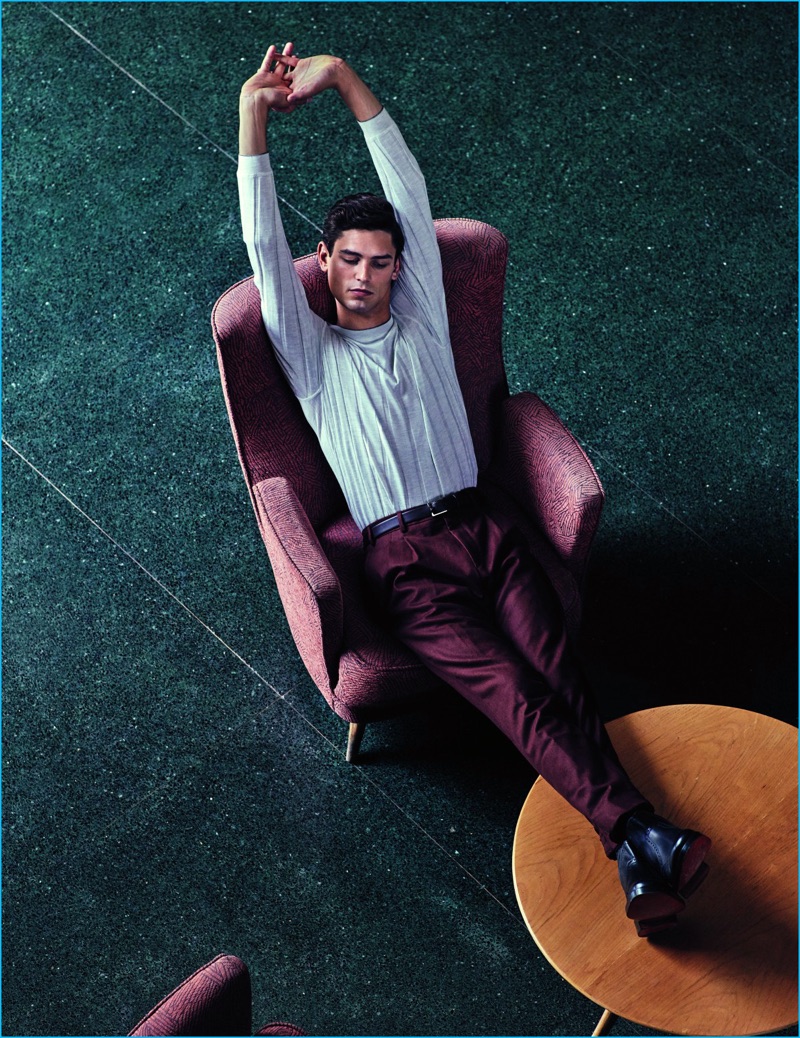 Stretching, Arthur Gosse sports a silk and cashmere top from Brunello Cucinelli with a Pal Zileri belt and trousers. Arthur's leather boots come from Hermes.
