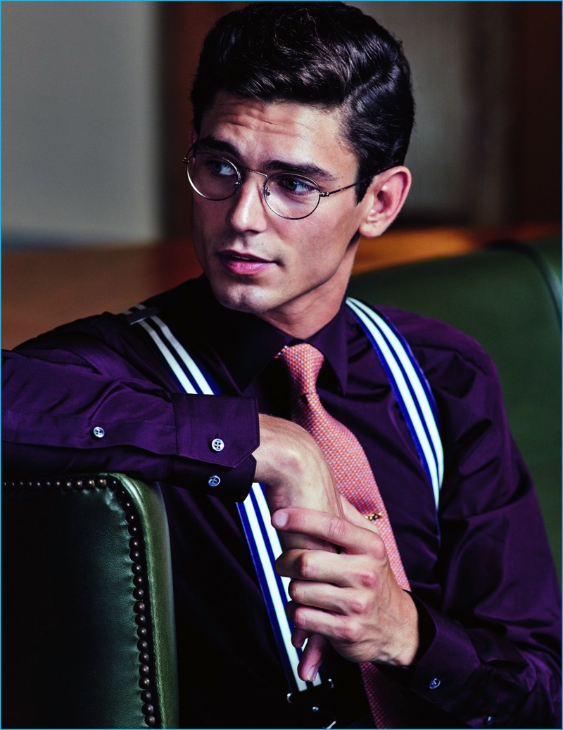 Model Arthur Gosse wears a burgundy Boss by Hugo Boss shirt, with a Hermes tie, Hackett London suspenders, and Giorgio Armani glasses.