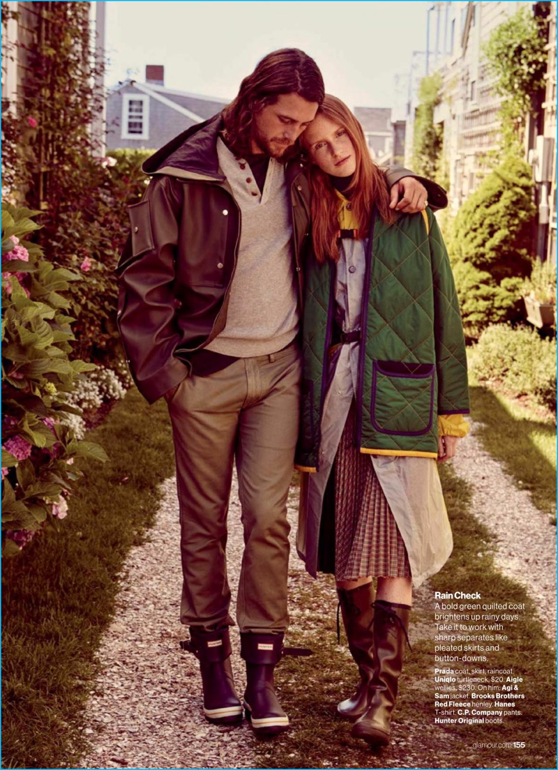 Ben Robson walks outdoors with Magdalena Jasek. Sporting an Agi & Sam jacket, Robson also wears a Brooks Brother Red Fleece henley with a Hanes t-shirt, C.P. Company pants, and Hunter Original boots for Glamour.