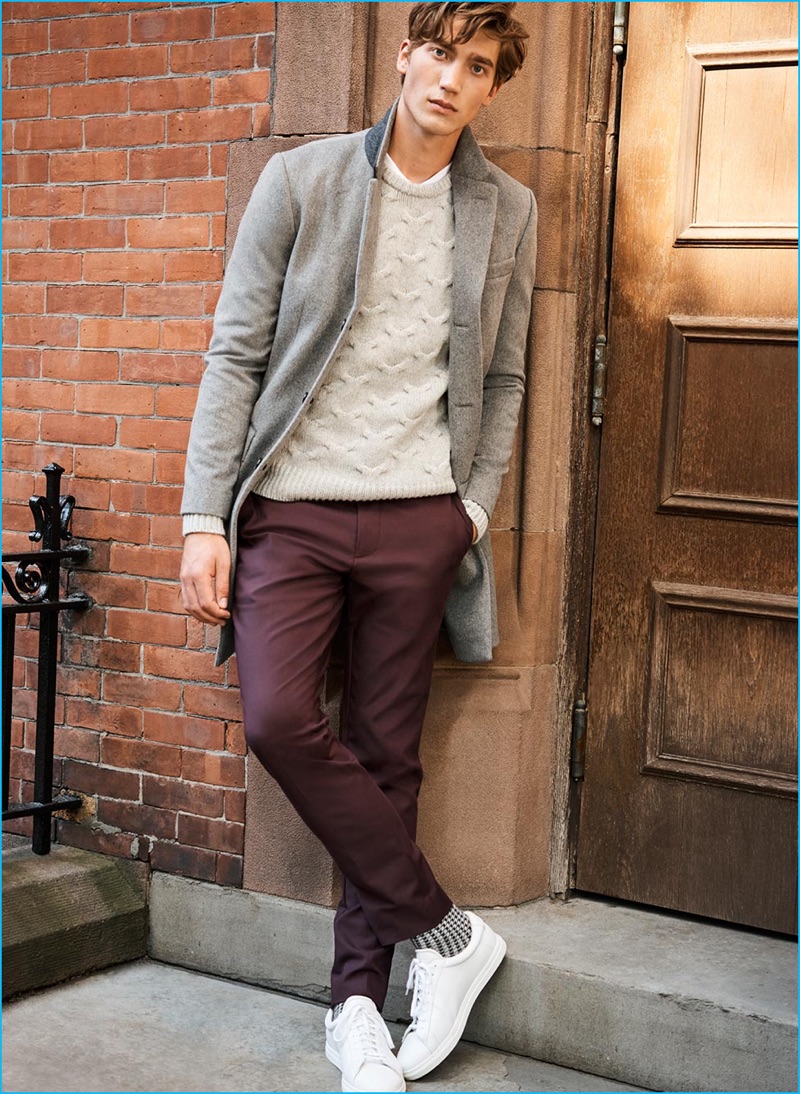 Going for a smart casual look from Club Monaco, Jeff Ryan wears a wool-cashmere topcoat, cable-knit sweater, burgundy modern stretch trousers and Zespas sneakers.