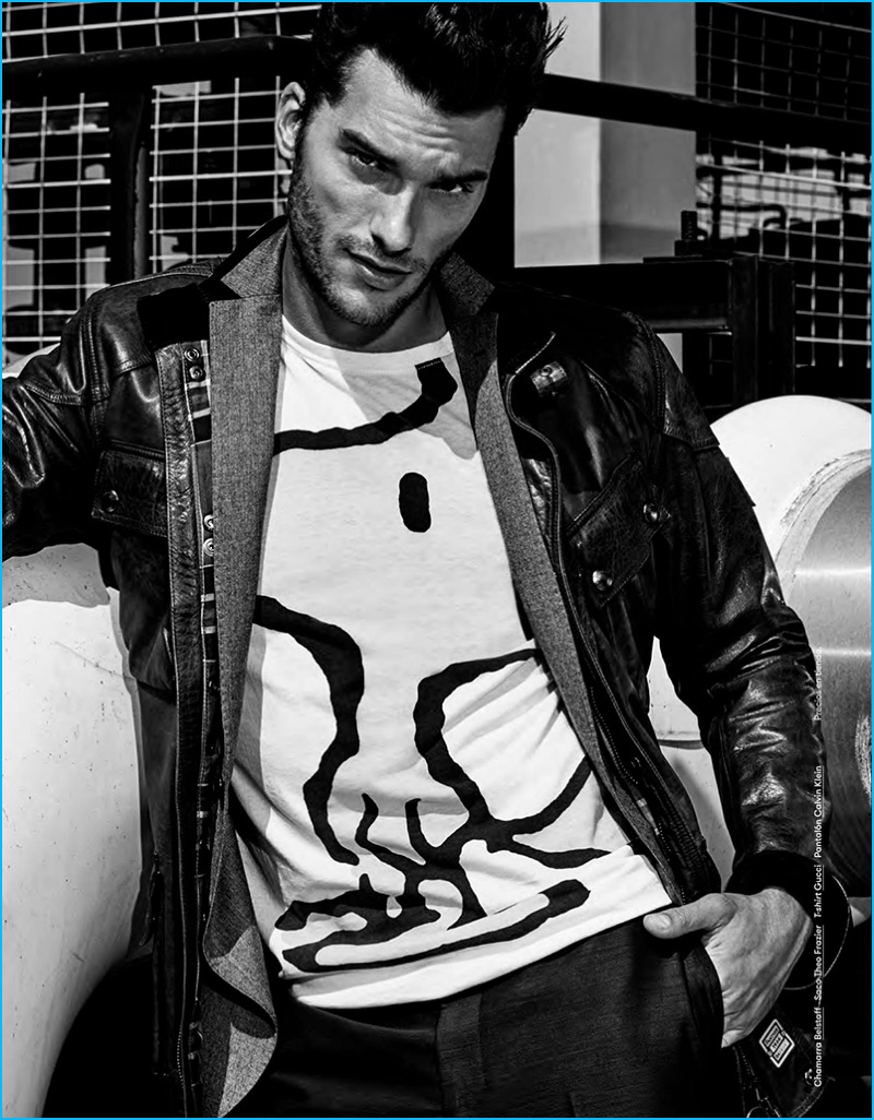 Aurelien Muller poses for a picture, wearing a Gucci Woodstock t-shirt with a Belstaff leather jacket and Calvin Klein pants.