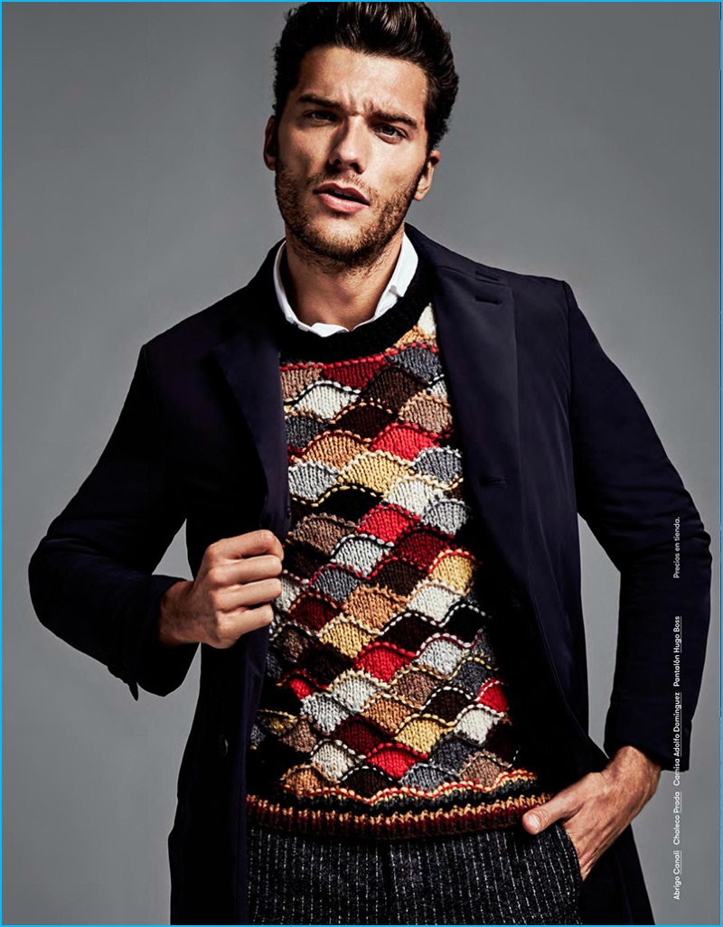 Models Aurelien Muller strikes a pose in a Canali coat, Prada intarsia sweater, Adolfo Dominguez shirt, and Hugo Boss trousers.