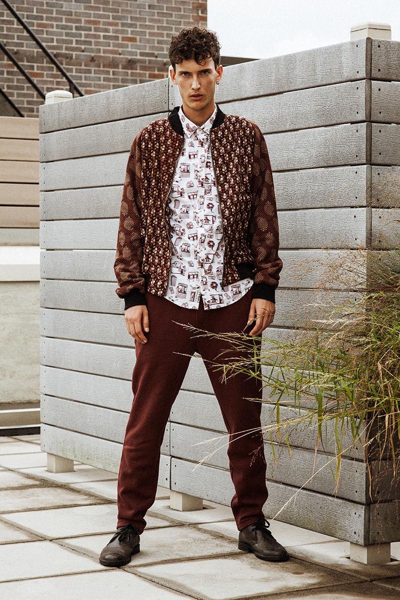 Going sporty, Dzhovani Gospodinov dons an Original Penguin printed shirt with a Lucio Castro bomber jacket, Steven Alan sweatpants, and John Varvatos shoes.