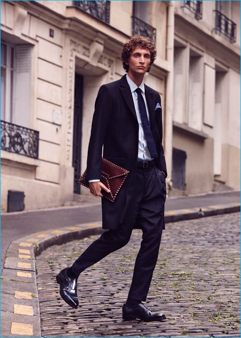 Lea Nielson photographs Florent Strambio in a Tiger of Sweden sport coat with a shirt, trousers, and tie from Balibaris. The model accessorizes with Santoni dress shoes. Florent also carries a leather Valentino document holder.