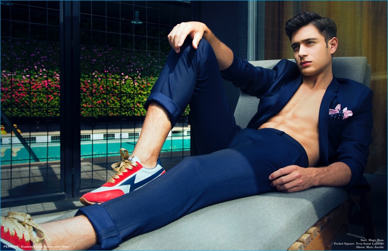Gabriel Conte dons a blue Hugo Boss suit with a Yves Saint Laurent pocket square and Marc Jacobs sneakers for Ferrvor.