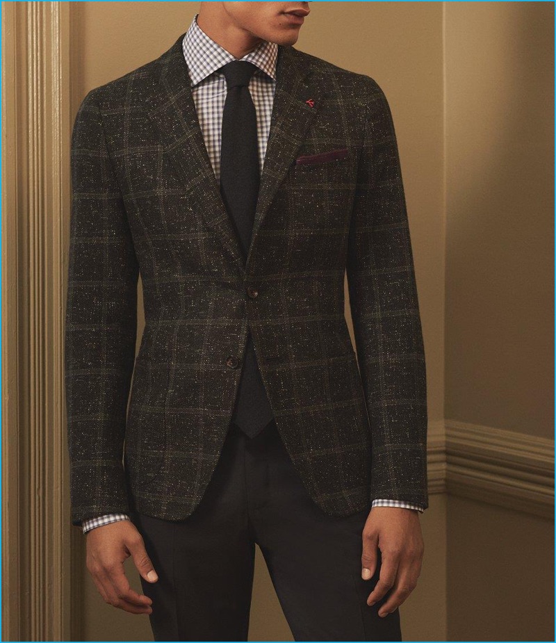Barneys New York spotlights ISAIA with a flecked plaid sport coat, checked dress shirt, and trousers with a cashmere necktie and pocket square.