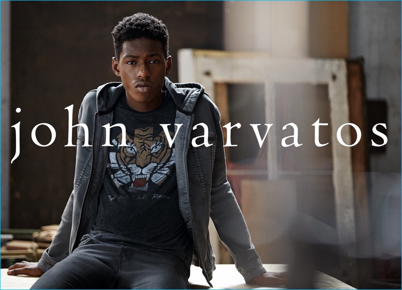 Sheani Gist goes casual in a graphic t-shirt, hoodie, and jeans from John Varvatos.