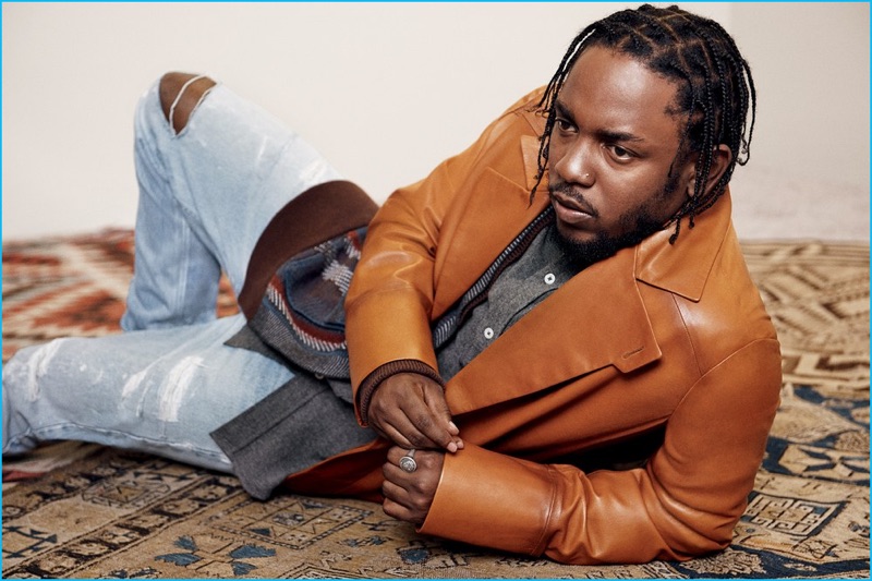 Appearing in a photo shoot for GQ Style's holiday issue, Kendrick Lamar wears a brown leather coat from Berluti. Lamar also wears a Berluti cardigan and Ami shirt.