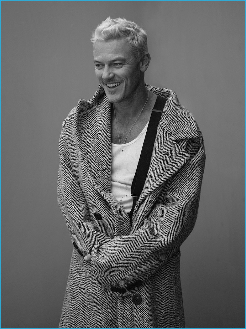 Wearing a herringbone Burberry coat with a vintage Calvin Klein tank and Giorgio Armani suspenders, Luke Evans is all smiles for Interview magazine.