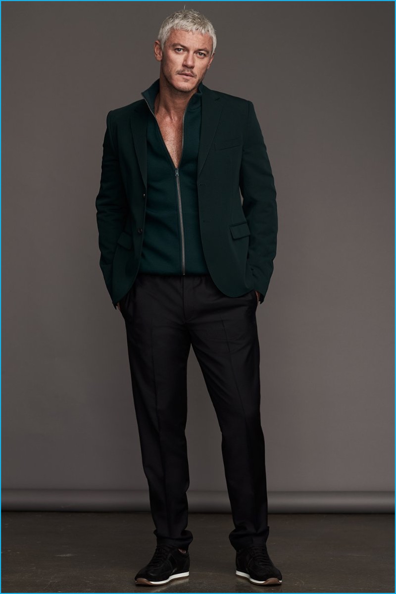 Channeling a sleek sporty aesthetic, Luke Evans wears a green Marni blazer, trousers and track jacket with Tom Ford sneakers.