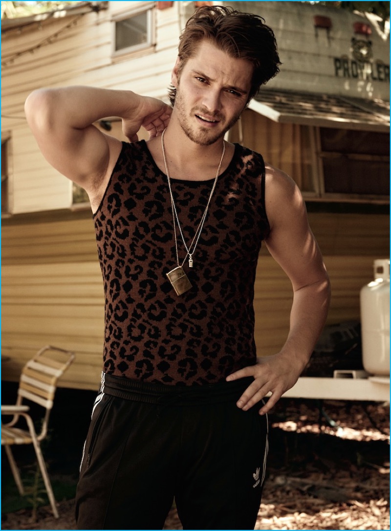 Appearing in a photo shoot for Interview magazine, Luke Grimes wears a Loewe leopard print tank with Adidas pants.