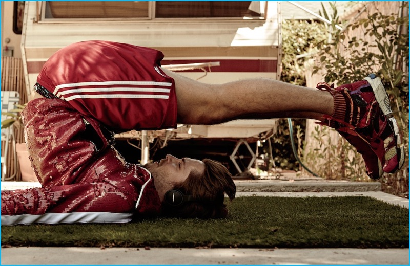 Luke Grimes gets in a workout for Interview, sporting a red sequined track jacket from Burberry with Adidas shorts, Huf boxers, and Helen Kirkum sneakers.
