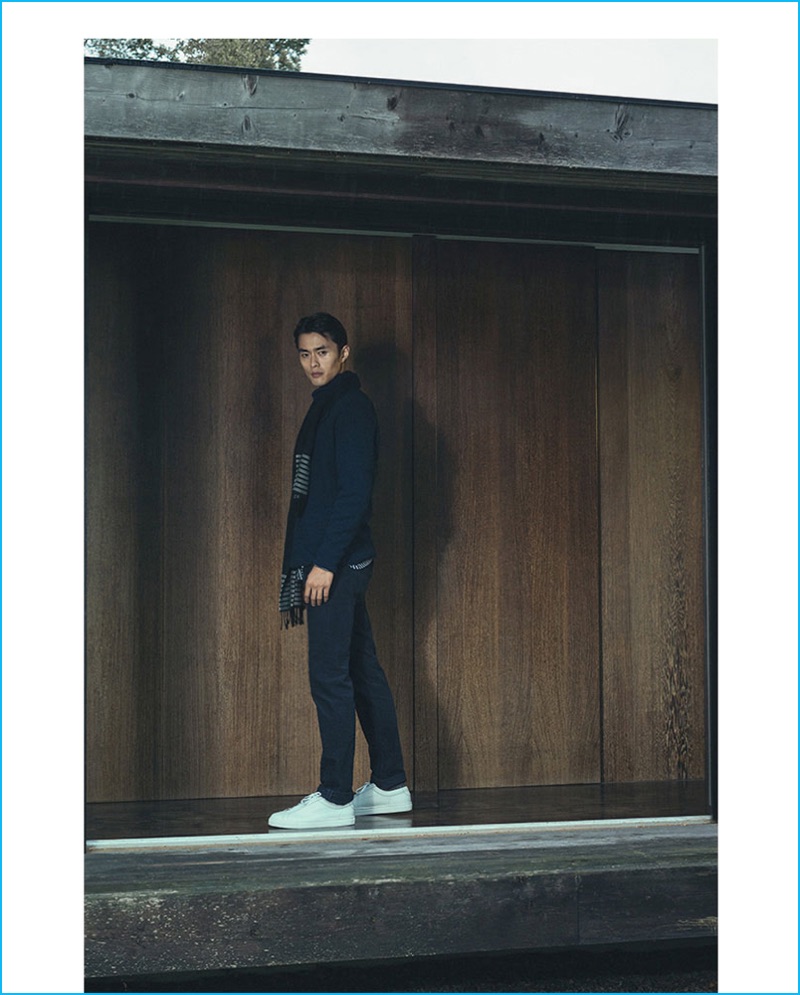 Zhao Lei models a double-breasted cardigan, striped shirt, corduroy jeans, striped wool scarf, and white leather sneakers from Massimo Dutti.