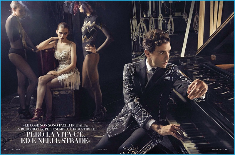 Sitting by the piano, Mika dons a studded suit from Italian fashion house Valentino.
