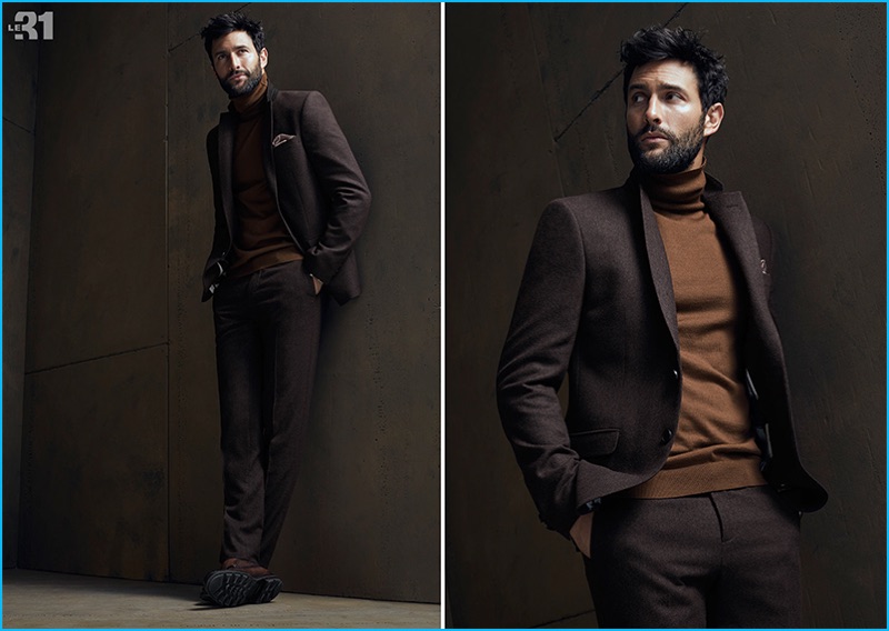 A smart vision, Noah Mills wears a slim suit with a chic turtleneck.