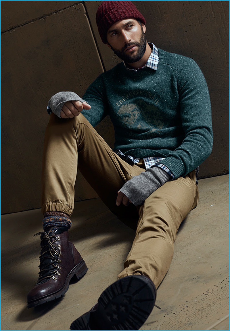 Noah Mills wears a flecked sweater, flannel shirt, joggers and a ribbed beanie from LE 31 with Steve Madden boots.