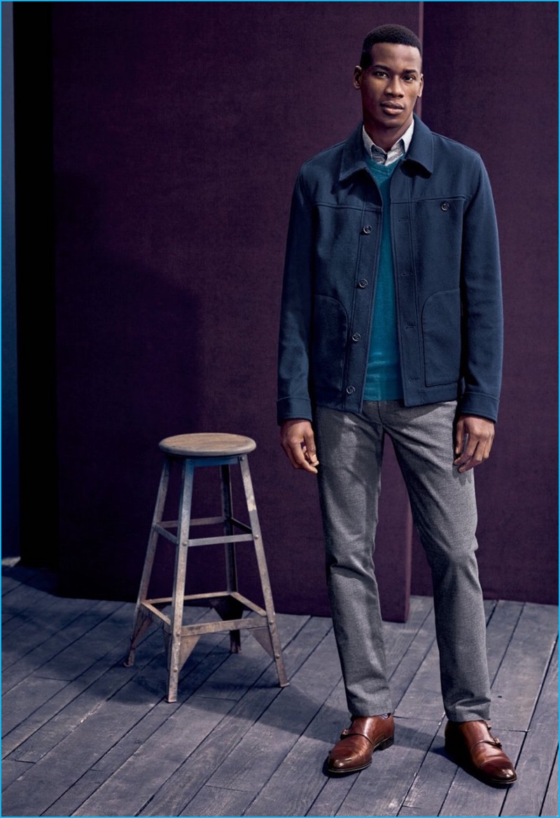David Agbodji wears a slim-fit jacket, v-neck sweater, shirt, and trousers from Ted Baker London with brown To Boot New York double monk leather shoes.