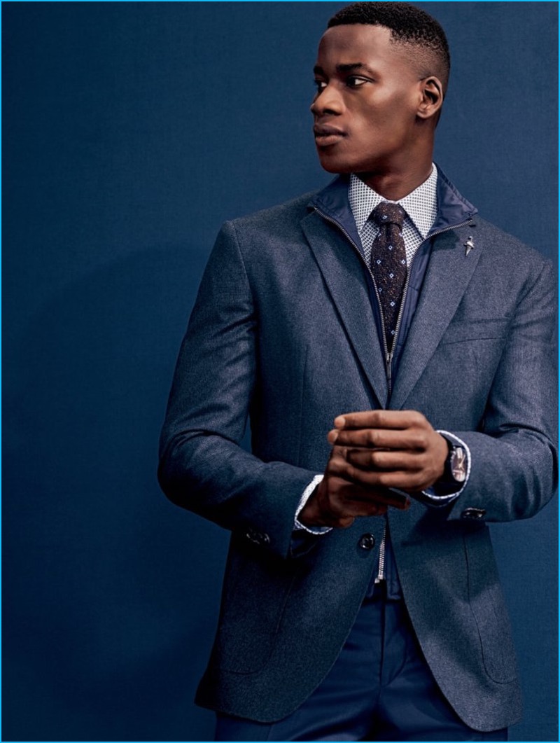 David Agbodji pictured in a houndstooth sport coat with wool trousers, and a smart shirt and tie from Ted Baker London.