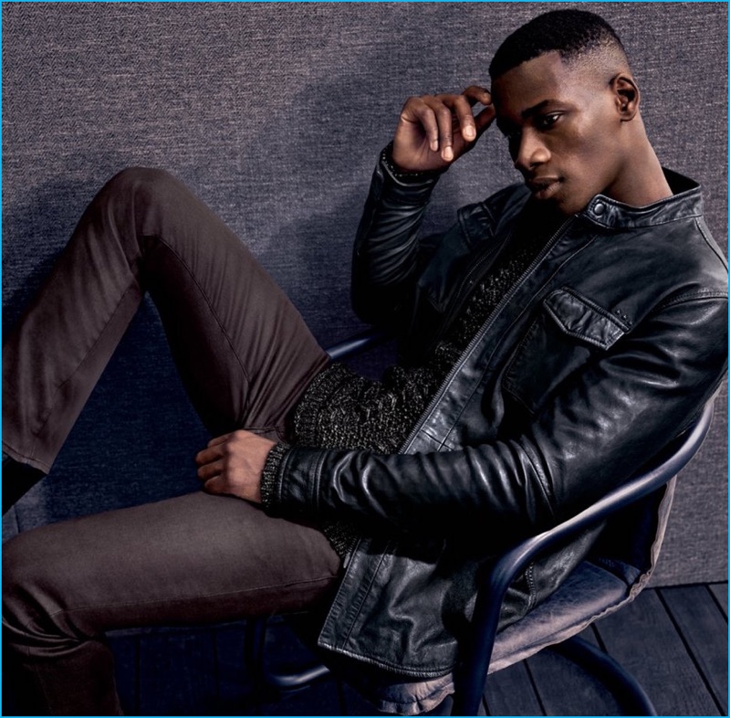 David Agbodji rocks a knit sweater, leather shirt jacket, and skinny jeans from John Varvatos Star USA.