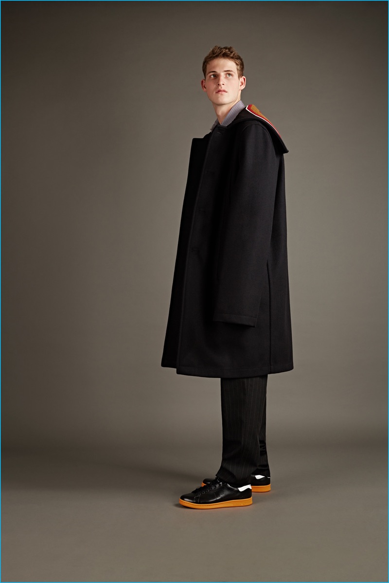 Raf Simons black wool overcoat, extra big long sleeved shirt, and pinstripe trousers with Adidas by Raf Simons Stan Smith sneakers.