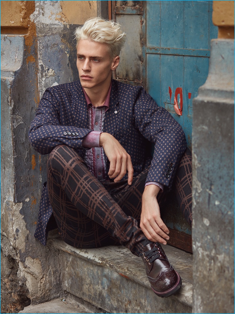 Stealing a quiet moment, Oliver Stummvoll models a Massimo Rebecchi jacket with a Bottega Veneta shirt, Vivienne Westwood trousers, and Giorgio Armani shoes.