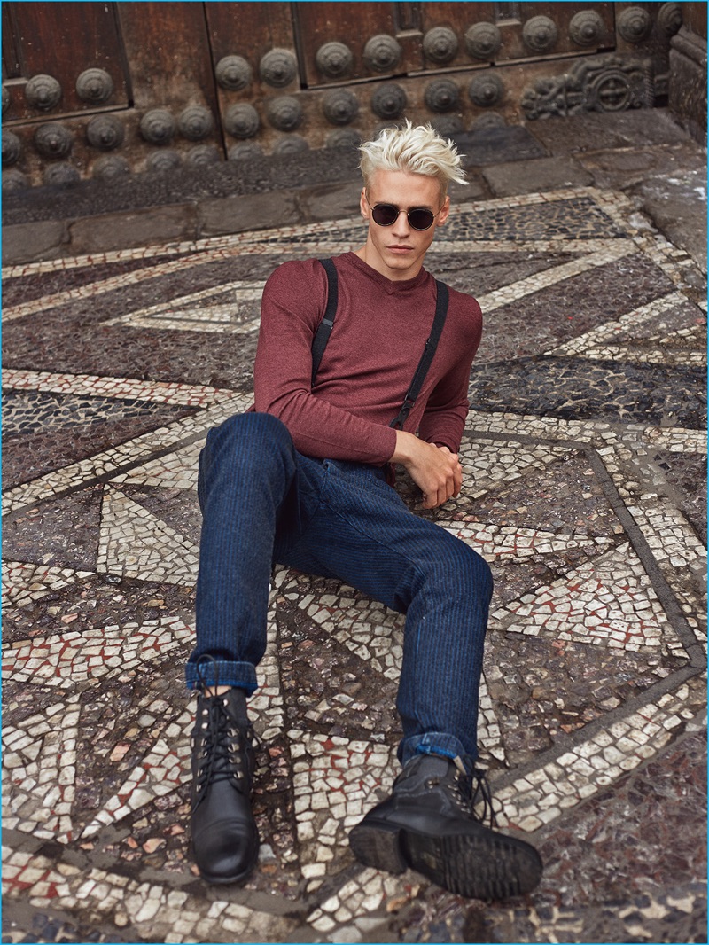 Model Oliver Stummvoll goes casual in a Ralph Lauren sweater, Diesel denim trousers, Ray-Ban sunglasses, and Giorgio Armani boots.