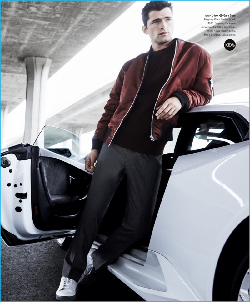 American model Sean O'Pry wears a burgundy bomber jackt, ribbed sweater, and trousers from Parisian brand Sandro.