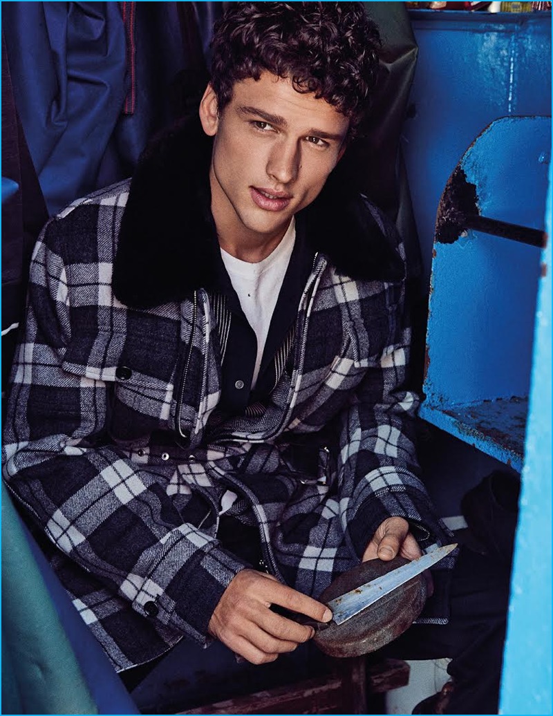 Simon Nessman wears a black and white plaid coat from Dior Homme with a Lanvin button-down, Gucci t-shirt, and Prada trousers for GQ Portugal.
