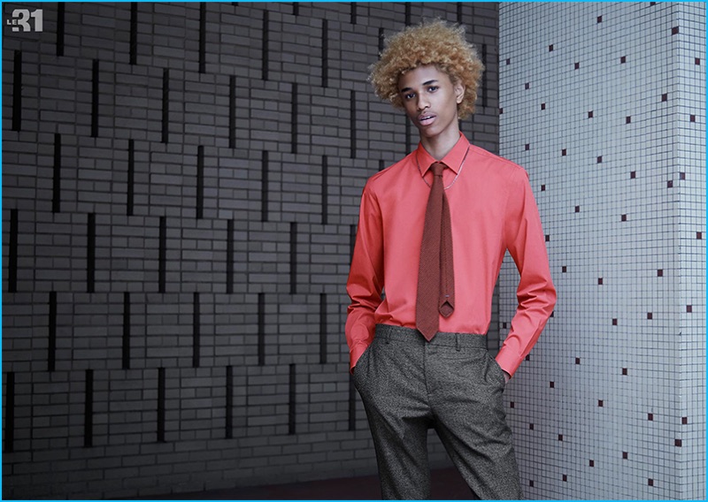 Model Michael Lockley dons a red stretch shirt and tone-on-tone stripe tie with flared 70s-inspired trousers from LE 31.
