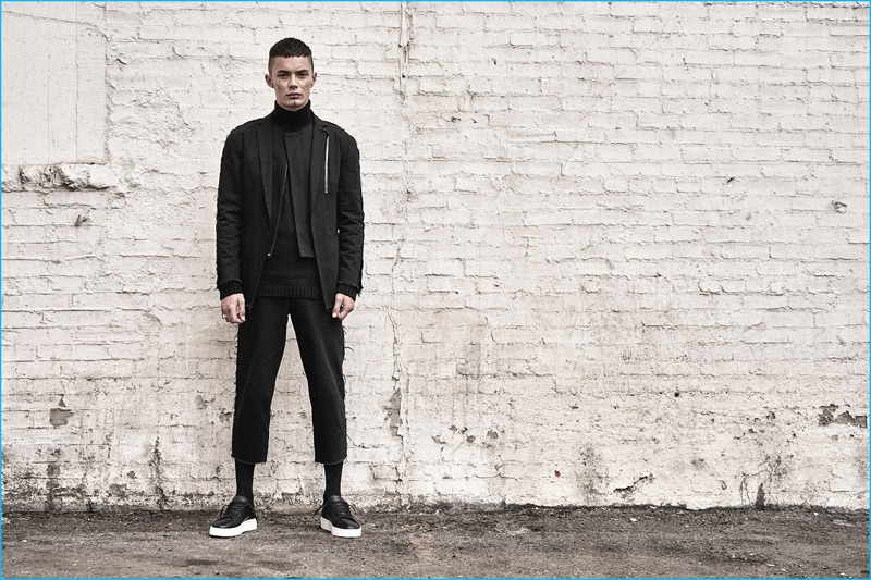 Model Simon Kotyk sports black fashions from the Stampd x United Arrows & Sons Purple Heart collection.
