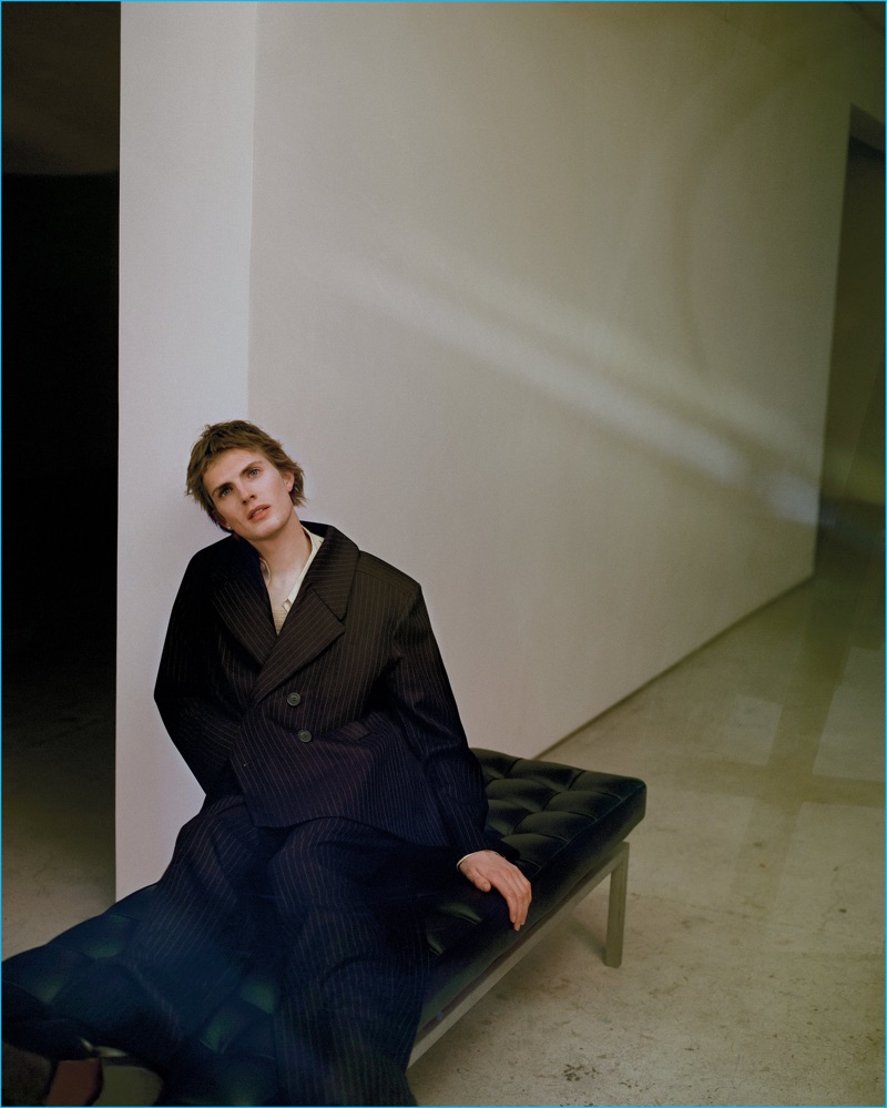 James Crewe models an oversized pinstripe Charles Jeffrey Loverboy double-breasted jacket and trousers with a Lemaire shirt.