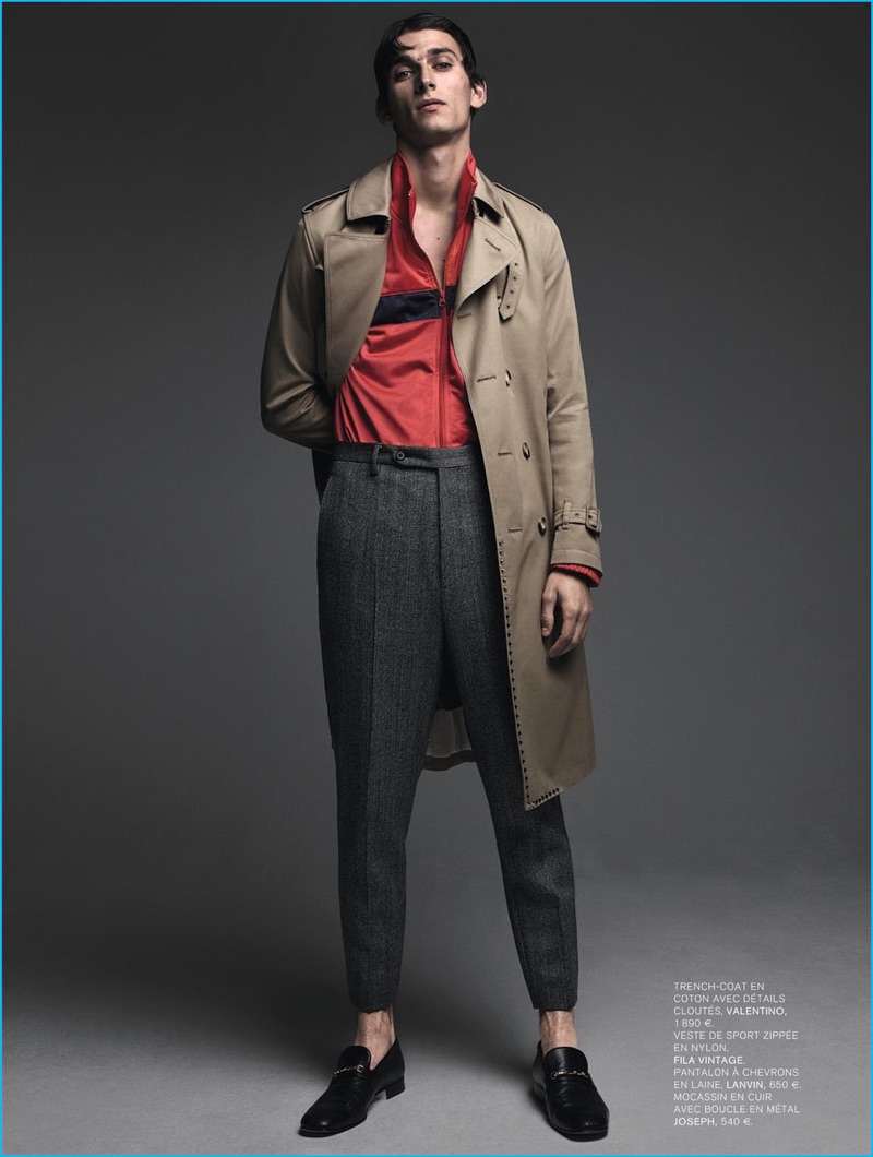 Standing tall, Thibaud Charon models a Valentino trench coat with a vintage Fila track jacket, Lanvin trousers, and Joseph dress shoes.